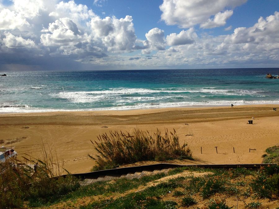 Golden bay on a slightly cloudy day with beautiful golden sands, dark blue crystal water and the clouds coming in off the horizon.