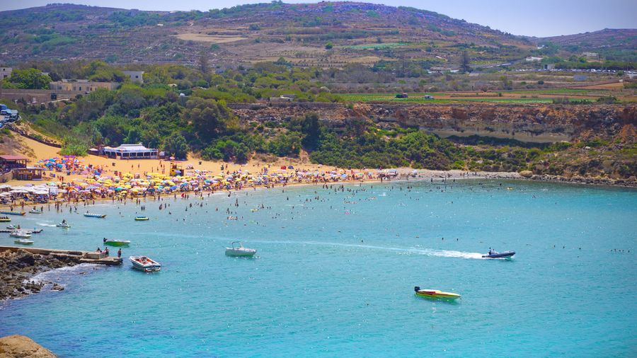 A beautiful photo of Golden Bay showing golden sands and clear blue water with the valley backdrop.